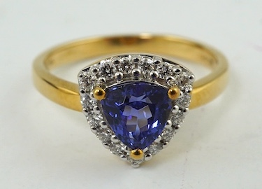 A modern 18ct gold, tanzanite and diamond cluster set ring, with AnchorCert report estimating the tanzanite to weight 1.01ct, size O, gross weight 4.4 grams. Condition - good